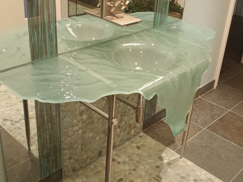 Waterfall wallmounted glass 60" wide sink on custom metal supports.